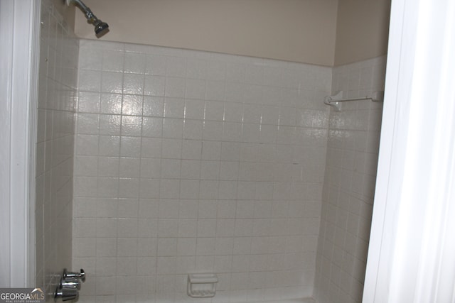 interior details featuring a tile shower