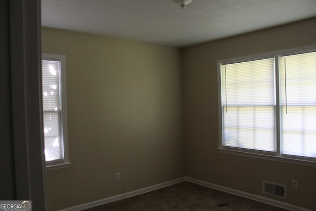 spare room featuring a textured ceiling and carpet