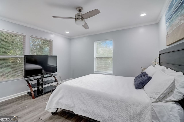 bedroom with ceiling fan, ornamental molding, hardwood / wood-style floors, and multiple windows