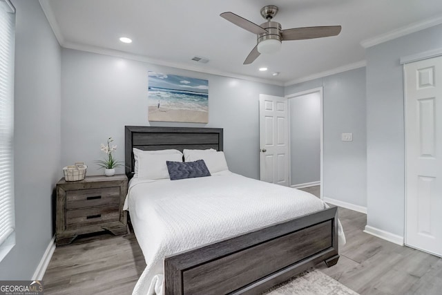 bedroom with ornamental molding, ceiling fan, and light hardwood / wood-style floors