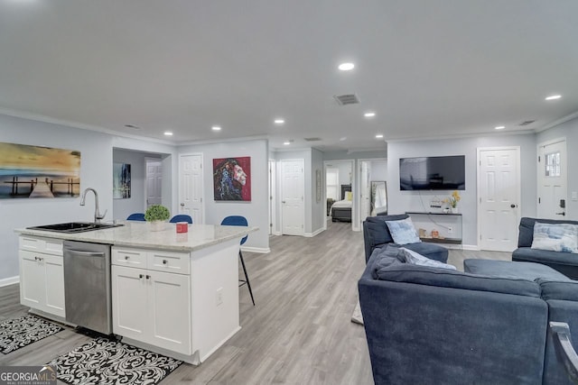 interior space featuring light wood-type flooring, ornamental molding, and sink