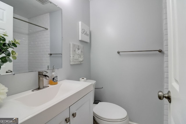 bathroom with vanity, toilet, and a shower