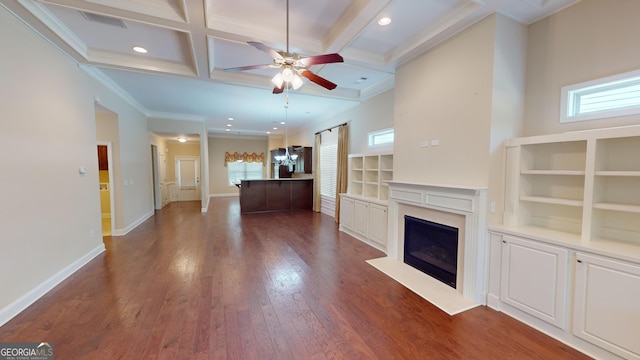 unfurnished living room featuring a healthy amount of sunlight, coffered ceiling, ceiling fan, and dark wood-style flooring