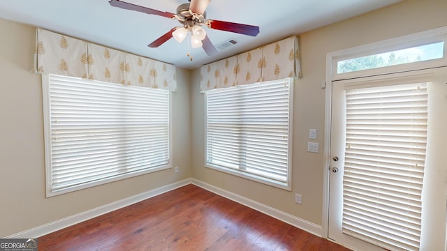 unfurnished dining area featuring wood finished floors, visible vents, baseboards, and ceiling fan