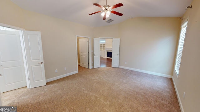 unfurnished bedroom featuring visible vents, baseboards, lofted ceiling, and carpet