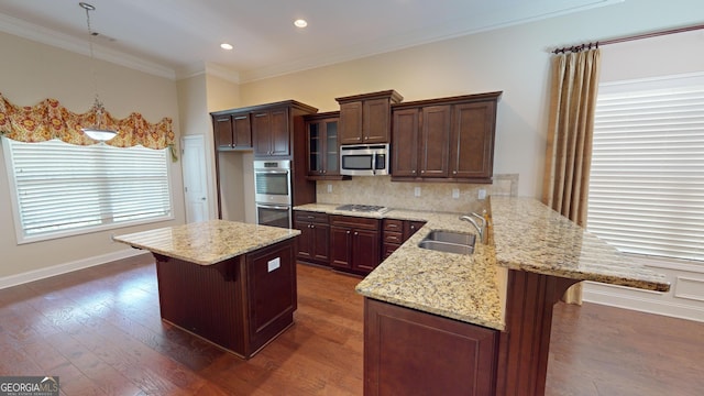 kitchen featuring a breakfast bar, dark wood-style flooring, stainless steel appliances, and a sink