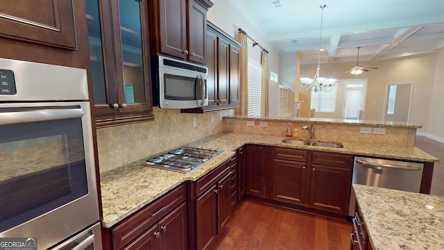 kitchen featuring appliances with stainless steel finishes, an inviting chandelier, dark wood-style floors, coffered ceiling, and a sink