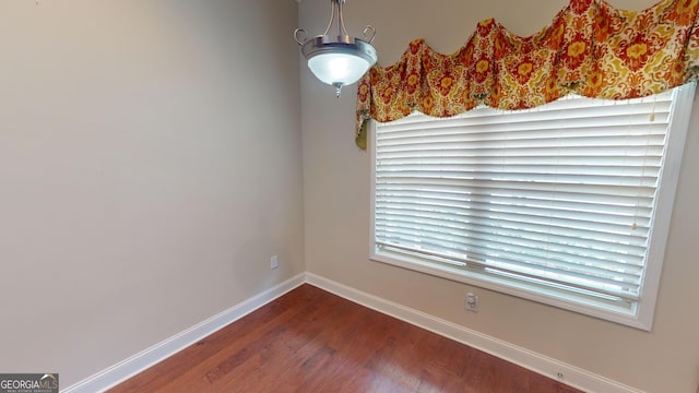 unfurnished dining area featuring baseboards and wood finished floors