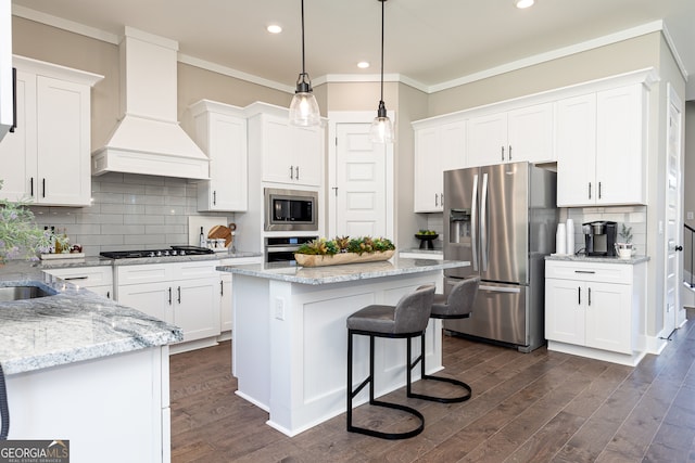 kitchen featuring premium range hood, appliances with stainless steel finishes, a center island, dark wood-type flooring, and white cabinets