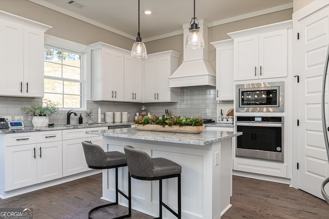 kitchen featuring white cabinets, stainless steel appliances, and custom exhaust hood