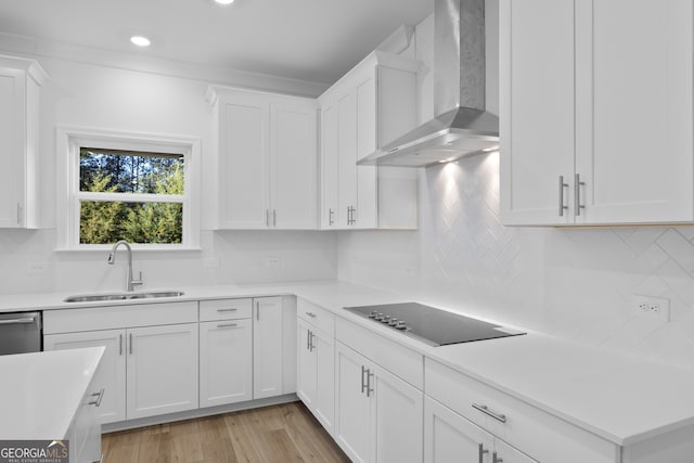 kitchen featuring dishwasher, sink, white cabinets, black electric cooktop, and wall chimney exhaust hood