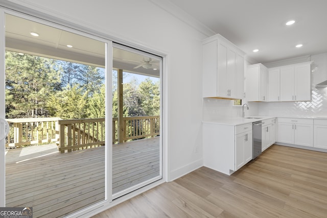 kitchen with dishwasher, white cabinets, light hardwood / wood-style floors, and decorative backsplash