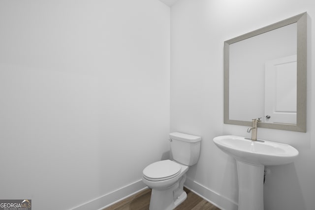 bathroom featuring wood-type flooring and toilet