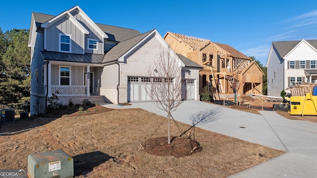 view of front of property with cooling unit, a garage, and covered porch