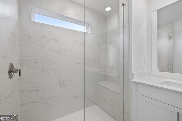 bathroom featuring a tile shower and vanity