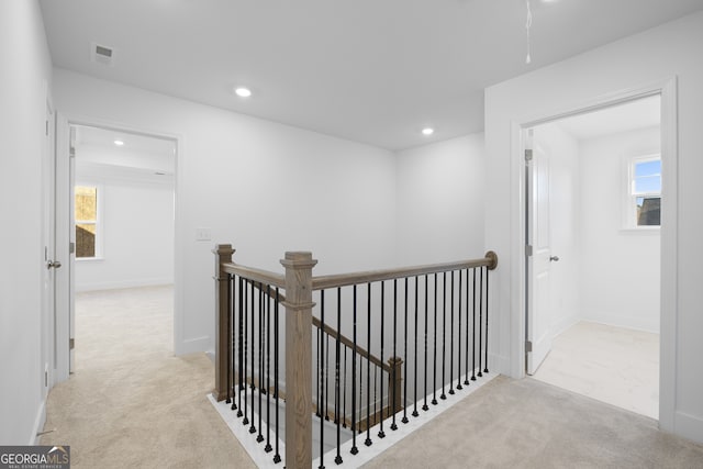 hallway featuring light colored carpet