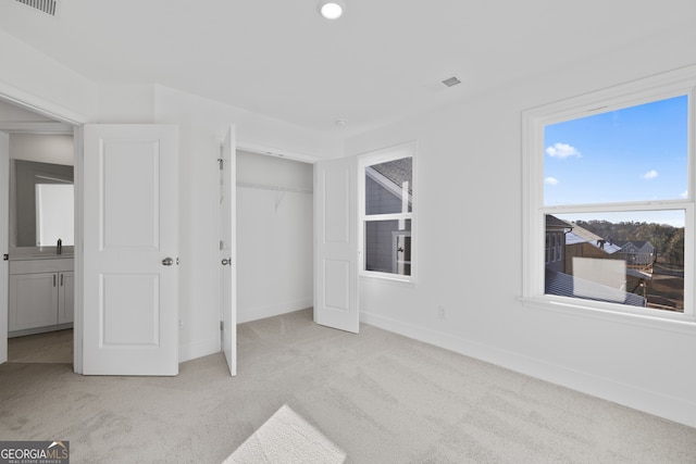 unfurnished bedroom featuring light carpet and a closet