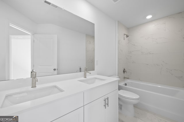 full bathroom with tiled shower / bath, vanity, and toilet