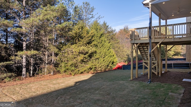 view of yard featuring a wooden deck and ceiling fan