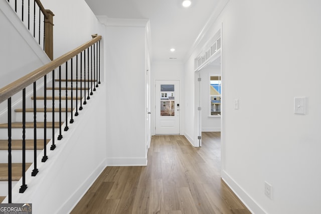 foyer featuring ornamental molding and light hardwood / wood-style flooring