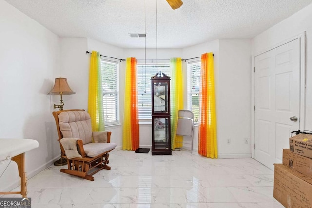 sitting room featuring a textured ceiling and ceiling fan