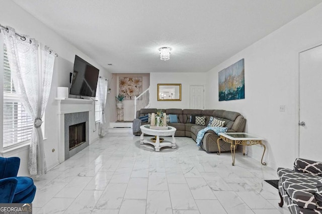 living room with a tile fireplace and a textured ceiling