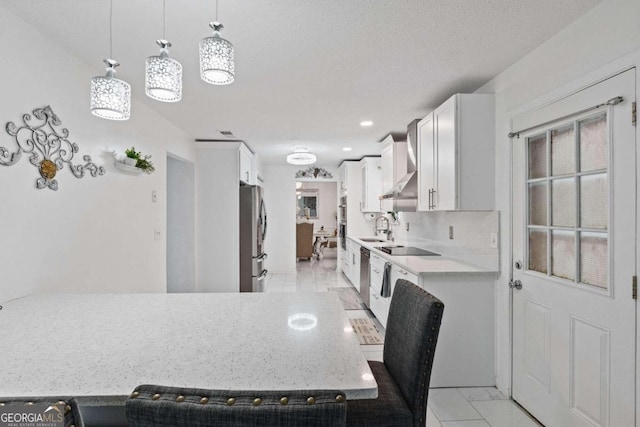 kitchen featuring appliances with stainless steel finishes, white cabinetry, sink, pendant lighting, and decorative backsplash