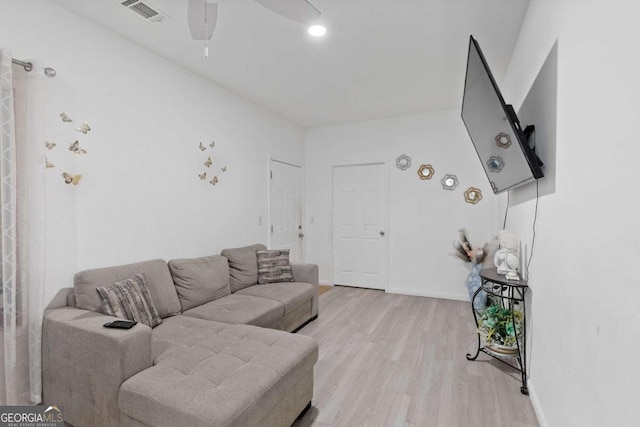 living room featuring ceiling fan and light hardwood / wood-style flooring