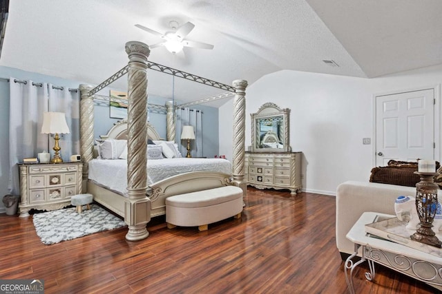 bedroom with vaulted ceiling, dark hardwood / wood-style flooring, ceiling fan, and a textured ceiling