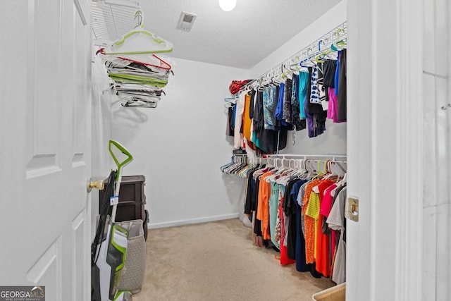 walk in closet featuring light carpet