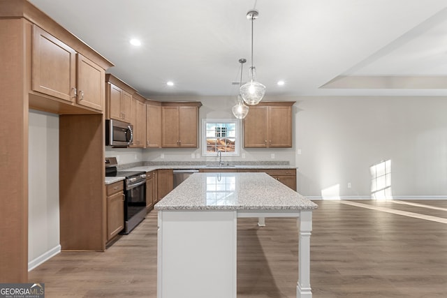707 Jasmine Dr, Macon, GA 31211 - kitchen featuring appliances with stainless steel finishes, a sink, baseboards, a kitchen island, and light wood-style flooring