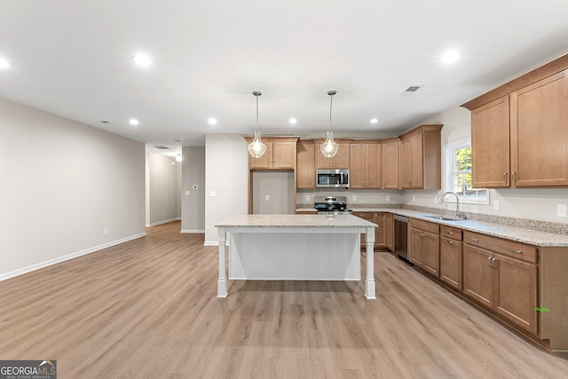 707 Jasmine Dr, Macon, GA 31211 - kitchen featuring appliances with stainless steel finishes, a sink, light wood-type flooring, brown cabinetry, and a kitchen island