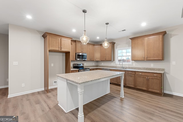707 Jasmine Dr, Macon, GA 31211 - kitchen with appliances with stainless steel finishes, brown cabinetry, light wood-style floors, a kitchen island, and recessed lighting