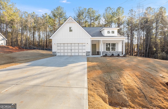707 Jasmine Dr, Macon, GA 31211 - modern farmhouse featuring stone siding, a porch, driveway, board and batten siding, and roof with shingles