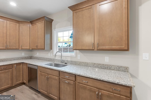 707 Jasmine Dr, Macon, GA 31211 - kitchen featuring dishwasher, a sink, light wood-type flooring, and light stone counters