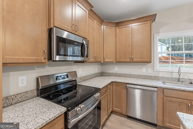 707 Jasmine Dr, Macon, GA 31211 - kitchen with appliances with stainless steel finishes, a sink, light stone counters, and light wood-style floors