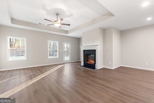 707 Jasmine Dr, Macon, GA 31211 - unfurnished living room featuring a tray ceiling, wood finished floors, plenty of natural light, ceiling fan, and recessed lighting