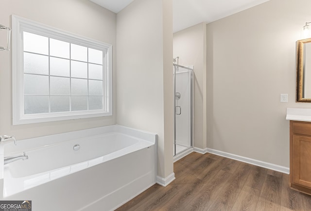 707 Jasmine Dr, Macon, GA 31211 - bathroom with vanity, wood finished floors, a stall shower, a bath, and baseboards