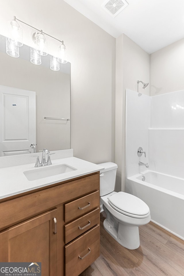 707 Jasmine Dr, Macon, GA 31211 - full bathroom featuring wood finished floors, vanity, toilet, and bathing tub / shower combination