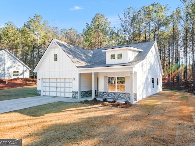 707 Jasmine Dr, Macon, GA 31211 - modern farmhouse featuring stone siding, board and batten siding, covered porch, concrete driveway, and a garage