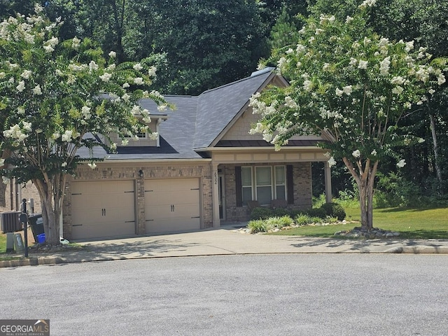 view of front of property featuring central AC unit and a garage