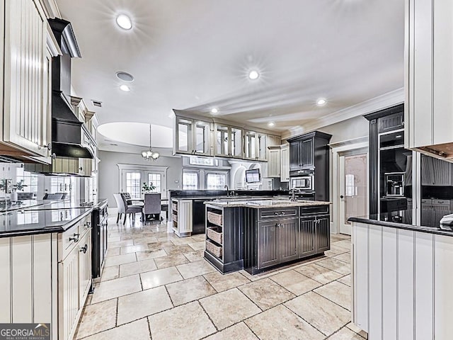 kitchen with white cabinets, hanging light fixtures, a kitchen island, and crown molding