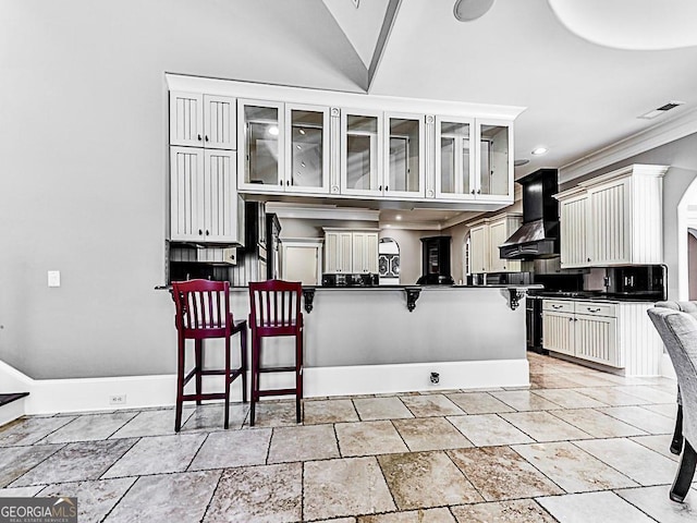 kitchen with white cabinets, custom exhaust hood, kitchen peninsula, tasteful backsplash, and a breakfast bar