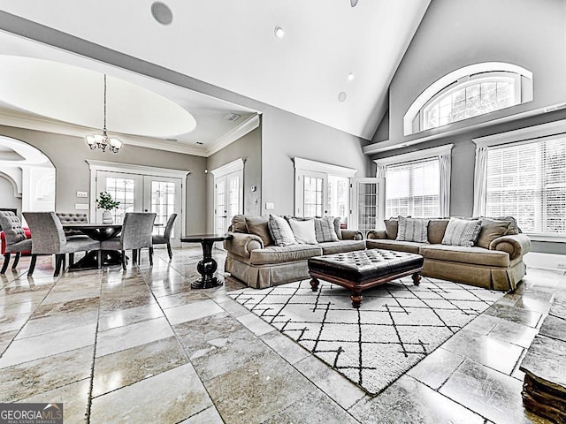 living room with crown molding, french doors, a high ceiling, and a notable chandelier