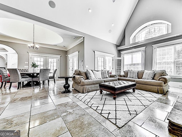 living room featuring arched walkways, a chandelier, crown molding, baseboards, and high vaulted ceiling