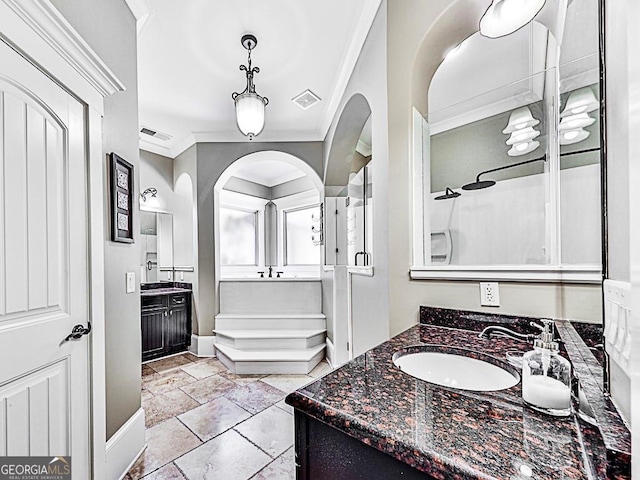 bathroom featuring two vanities, a shower stall, crown molding, and baseboards