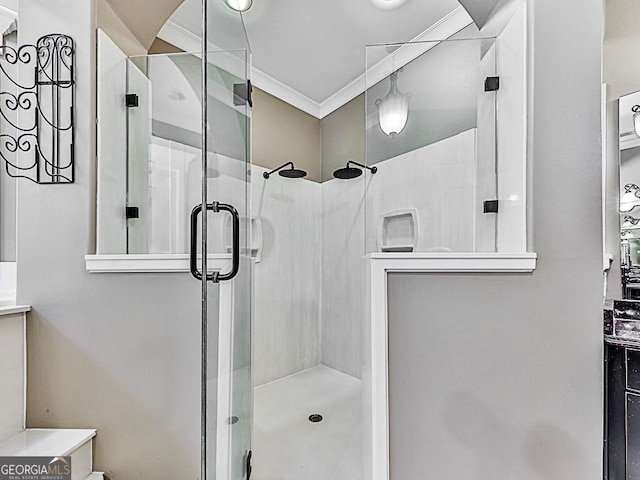 bathroom featuring a shower with door, ornamental molding, and vanity