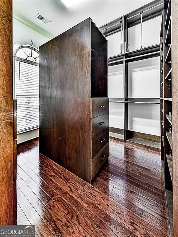 spacious closet featuring dark hardwood / wood-style floors