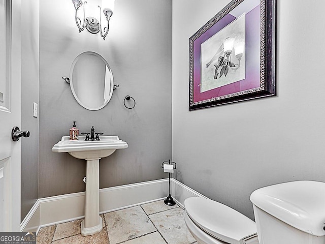 bathroom featuring toilet and baseboards