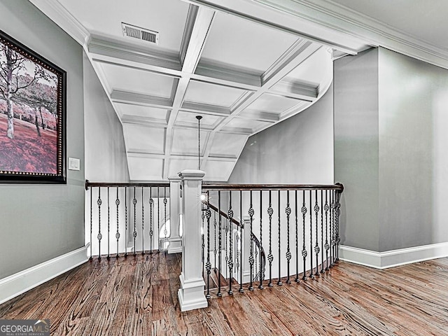 stairway with crown molding, coffered ceiling, wood-type flooring, and beam ceiling